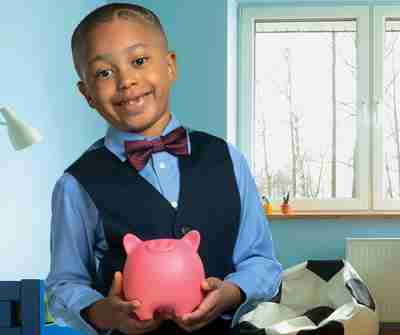 A young boy holding a piggy bank.