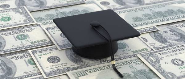 Black graduation cap sitting on one hundred dollar bills